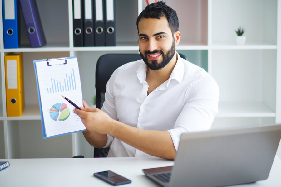 Estrategias omnicanal claves para desarrollar - Hombre mostrando gráficos en una presentación de oficina.
