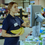 Inteligencia artificial en la auditoría - Cajera registrando plátanos en el supermercado.
