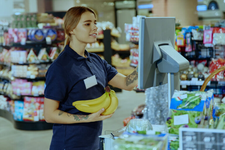 Inteligencia artificial en la auditoría - Cajera registrando plátanos en el supermercado.