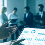 Ejecutivo señalando gráficos en tablet durante reunión corporativa.